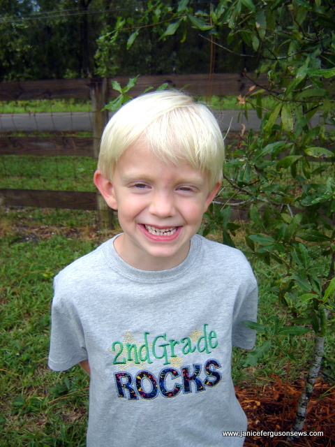 With a goofy grin, Robert, 6, stands next to his birthday tree.