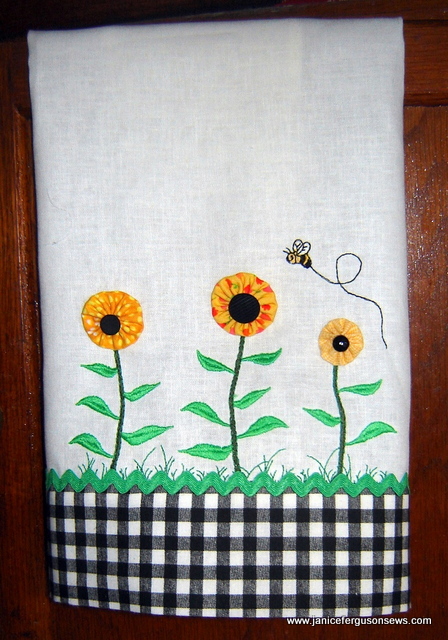 Yo-yo flowers with button centers, rick rack and a turn tube hem transform a plain white dishtowel to something more interesting.